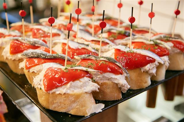 빵 위에 올린 갖가지 음식을 고정하기 위해 나무꼬치를 쓰는 스페인 바스크 지역에서는 핀초스라고 불리기도 한다.