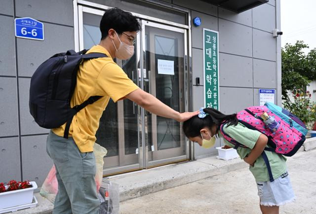 김 교사가 학교 앞에서 기다리고 있던 소연이에게 인사를 받으며 머리를 쓰다듬어 주고 있다. 보령=왕태석 선임기자