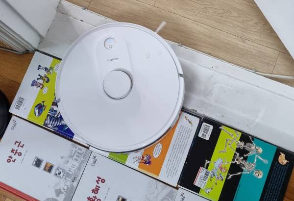 아이리버 에이클 로봇청소기 INS-100으로 높이 2센티미터 이상의 문턱을 넘도록 하기 위해 책 6권을 문턱 앞에 놓고 청소기가 차례로 올라타도록 했다. 정옥재 기자