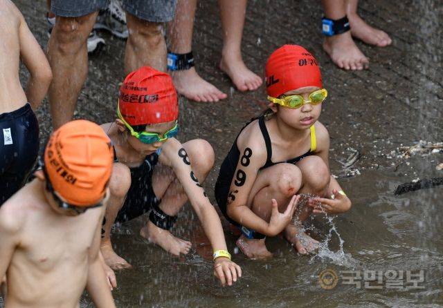 31일 서울 송파구 잠실 한강공원 수중보 일대에서 열린 제18회 서울특별시 철인3종협회장기 아쿠아슬론대회에서 어린 참가자들이 수영하기에 앞서 몸에 물을 적시고 있다.