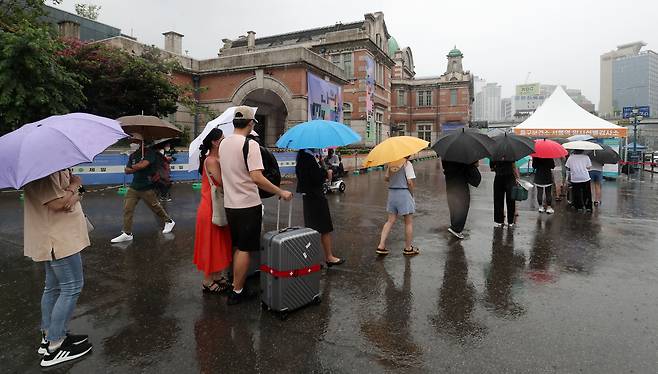 빗속 코로나 검사 - 31일 우산을 쓴 시민들이 서울 중구 서울역 광장에 설치된 코로나 임시 선별검사소 앞에 줄을 서있다. 이날 코로나 신규 확진자는 7만3589명으로 지난 27일 이후 나흘 연속 하락세를 보였지만, 위중증 환자는 284명으로 1주일 전에 비해 2배 가까이 늘었다. /뉴스1