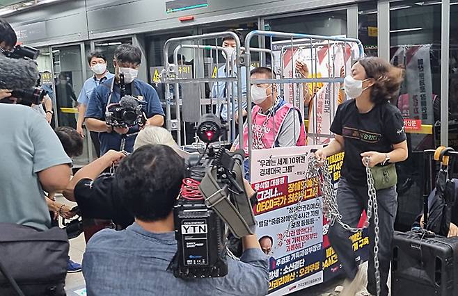 전국장애인차별철폐연대 활동가가 1일 서울 종로구 지하철 5호선 광화문역에서 장애인 이동권 및 예산 확보를 촉구하는 시위에서 자신의 몸을 이동식 철제 칸막이에 쇠사슬로 묶었다. 연합뉴스