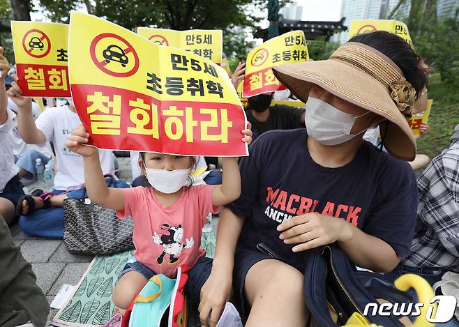 1일 서울 용산구 대통령집무실 앞에서 열린 만 5세 초등학교 조기입학 학제개편안 반대 기자회견에서 한 아이가 피켓을 들어 구호를 외치고 있다. 이들은 "학부모들은 의무교육이 시작되는 시점을 본격적인 학습의 시기로 인지해, 조기 취학에 대비하기 위해 영유아단계부터 선행학습을 하는 과잉 사교육 열풍이 일어날 수 있다＂며 문제점을 꼬집었다. 2022.8.1/뉴스1 ⓒ News1 이성철 기자