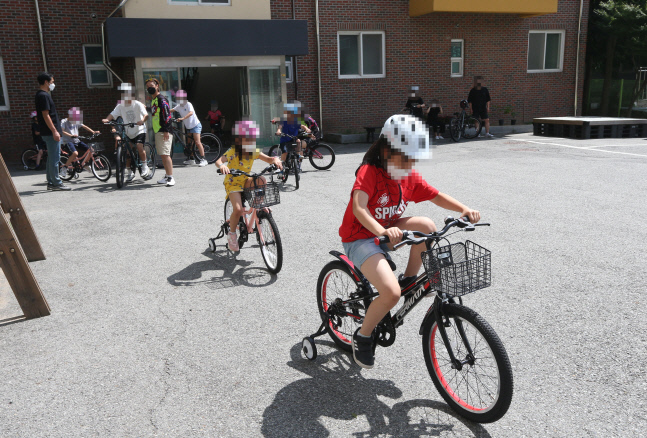 복지관 아이들이 경륜선수의 교육을 받으며 자전거를 타고 있다.