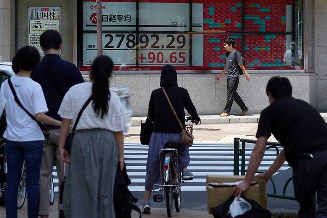 1일 도쿄의 닛케이 지수 안내판이 보이는 거리를 사람들이 지나가고 있다. /AP연합뉴스