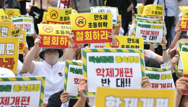 '만 5세 초등학교 취학 저지를 위한 기자회견'에 나온 참석자들이 1일 서울 용산 대통령실 인근에서 손 피켓을 들고 항의하고 있다. 이한형 기자