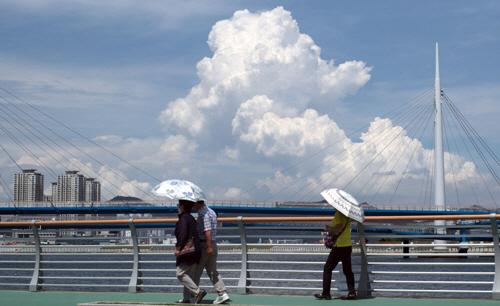 양산을 쓴 시민이 경남 창원시 한 산책로를 걷고 있다. 기사와 직접적 관련이 없음. [사진 출처 = 연합뉴스]