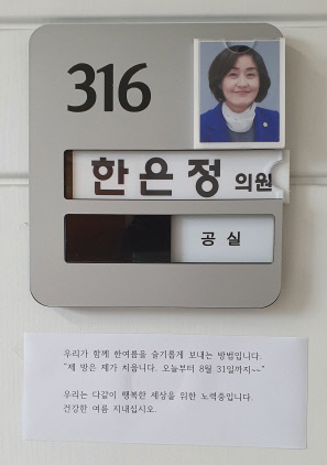 ▲한은정 의원(사진)이 청소노동자와 슬기로운 여름을 보내자는 글을 의원실 문에 붙여 놓고 있다.ⓒ창원시의회 김유미 주무관