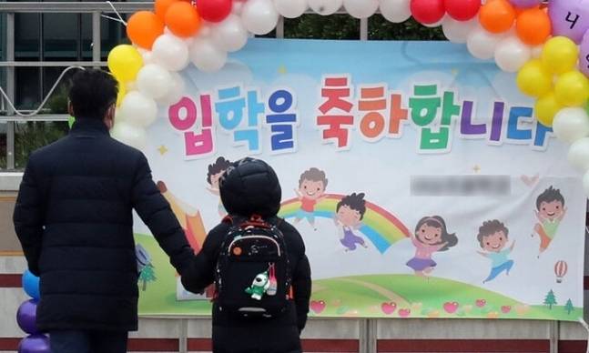 지난 2021년 3월 2일 한 초등학교에서 입학생이 학부모의 손을 잡고 입학식 포토존 앞으로 걸어가는 모습. 연합뉴스