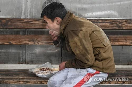 아프간 수도 카불의 버스정류장에서 음식을 먹는 아이. [AFP 연합뉴스 자료사진. 재판매 및 DB 금지]