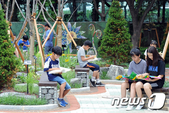 10일 오전 대구 중구 삼덕초등학교에서 학생들이 도심 속 녹색 쉼터인 '명상숲'에서 책을 읽고 있다. '명상숲'은 청소년들에게 정서안정과 감정순화에 도움을 주기위해 추진한 사업이다. 특히 각종 나무등 다양한 꽃으로 화단을 조성해 학생들과 지역 주민들에게 큰 호응을 받고 있다. 2017.7.10/뉴스1 ⓒ News1 이종현 기자