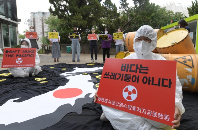 세계 해양의 날을 맞아 8일 서울 종로구 환경운동연합 마당에서 열린 일본 후쿠시마 방사성 오염수 방류 계획 철회 촉구 기자회견에서 참석자들이 손 피켓을 들고 있다. 20220608. 연합뉴스