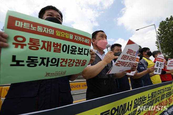 [서울=뉴시스] 백동현 기자 = 전국서비스산업노동조합연맹 조합원들이 29일 오전 서울 용산구 대통령집무실 앞에서 기자회견을 열고 대형마트 의무휴업 폐지 시도 중단을 촉구하고 있다. 2022.07.29. livertrent@newsis.com