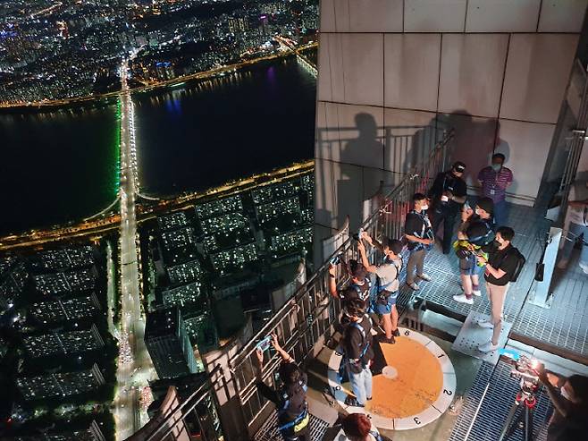 ‘써머레스트 2020’ 랜턴 비박 참가자들이 야경을 감상하고 있다.(사진=롯데물산)