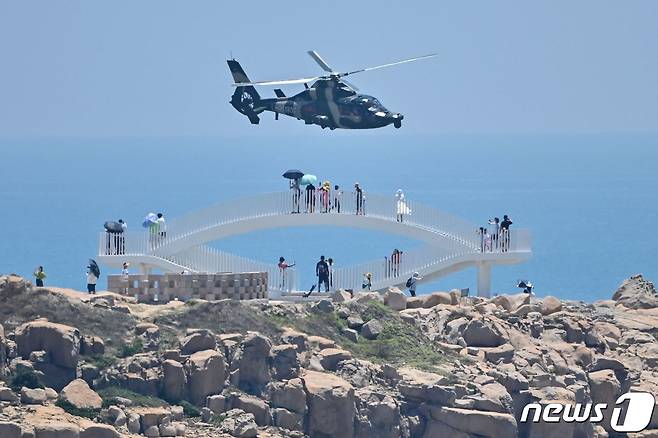 중국 관광객들이 4일 푸젠성 핑탄섬을 지나 날아가는 중국군 헬리콥터를 지켜보고 있다. 2022. 8. 4. ⓒ AFP=뉴스1 ⓒ News1 이종덕 기자