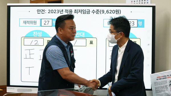 박준식 위원장(오른쪽)과 근로자 위원인 이동호 한국노총 사무총장이 인사하고 있다. 연합뉴스