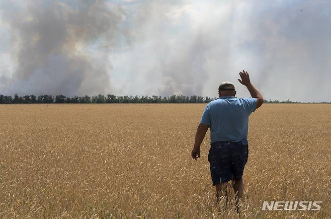 [드니프로페트로우스크=AP/뉴시스] 4일(현지시간) 우크라이나 드니프로페트로우스크에서 한 농민이 우크라이나군과 러시아군의 전투로 자신의 밭이 불에 타는 모습을 지켜보고 있다. 2022.07.05.