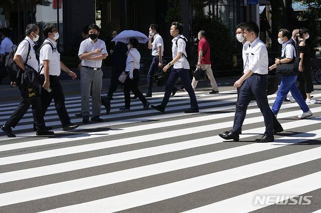 [도쿄=AP/뉴시스] 29일 일본 도쿄에서 코로나19 확산을 막기 위해 마스크를 쓴 사람들이 건널목을 건너고 있다. 2022.07.29