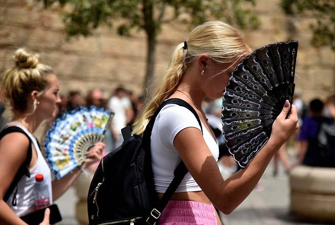 올해 6월 때 이른 폭염이 이어지는 스페인 남부 세비야 거리에서 여성들이 부채질을 하며 걸어가고 있다. 당시 세비야와 인근 코르도바 기온은 40도, 익스트리마두라의 과디아나 밸리는 42도, 남부 지방은 43도를 기록했다. 스페인에서 6월 초 이상 고온 현상은 최소 20년 만에 처음 있는 일이다. / 연합뉴스