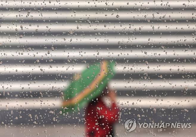 소나기 (서울=연합뉴스) 이지은 기자 = 소나기가 내린 22일 오후 서울시청 인근에서 한 시민이 우산을 쓴 채 이동하고 있다. 2022.7.22 jieunlee@yna.co.kr