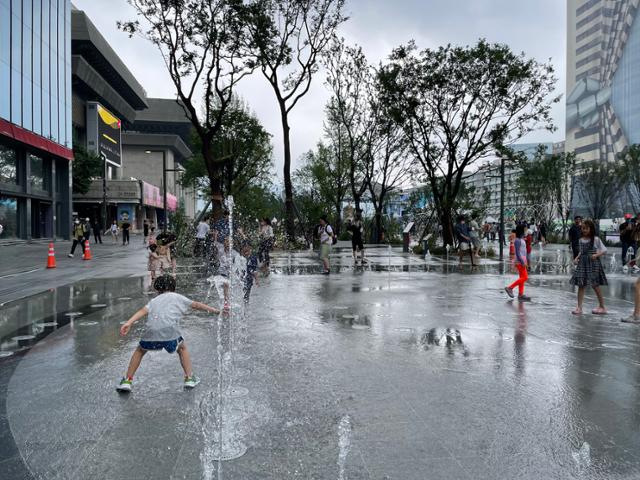 6일 개장한 서울 광화문광장 '바닥우물'에서 아이들과 시민들이 물놀이를 하고 있다. 기존 6차로를 없애 확보한 면적에 정원과 분수 등 이용객들의 휴식 공간을 넓혔다. 강지원 기자