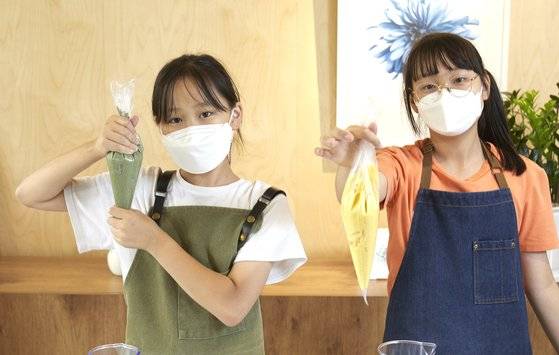 소중 학생기자단이 쑥(왼쪽)·단호박 구움찰떡 반죽을 미니 머핀틀에 채우기 위해 짜는 주머니에 담아냈다.