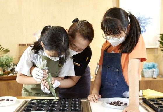 미니 머핀틀에 반죽을 채우는 걸 도와주는 김선이(가운데) 매니저. 반죽은 틀 크기에 맞춰 채워야 예쁜 모양으로 구워진다.