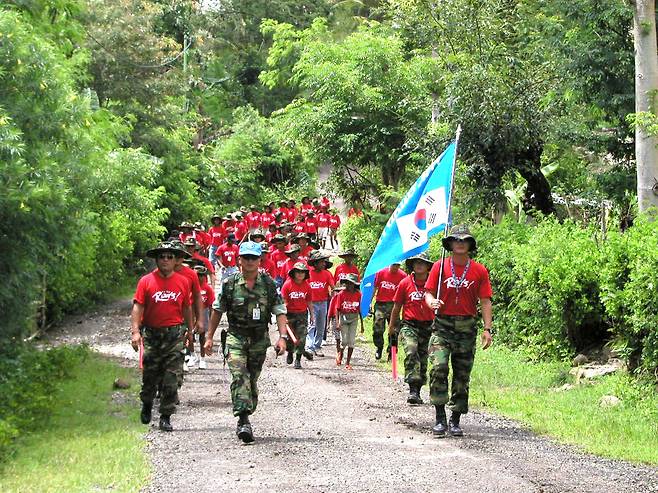 2003년 2월 상록수부대원들이 동티모르 오에쿠시 지역 청소년들과 함께 국토 순례에 나서고 있다. 국토순례 대행진 총 책임자로서 선두에 선 인솔자(가운데)가 2003년 3월 임무 수행 중 순직한 5명 중 한 명인 1지역대장 故 박진규 중령이다. 상록수부대 7진 제공