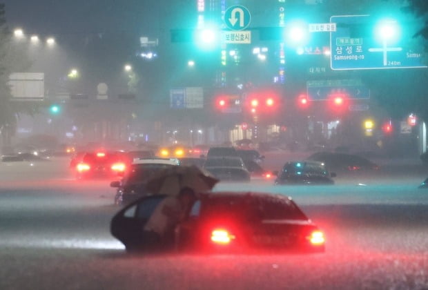8일 밤 서울 강남구 대치역 인근 도로에서 차량이 침수되자 운전자가 대피하고 있다. /사진=연합뉴스
