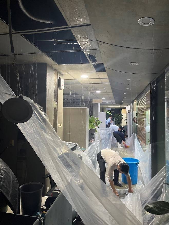 8일 한국투자증권 본사 사옥에 침수 피해가 발생해 직원들이 물을 퍼내고 있다.