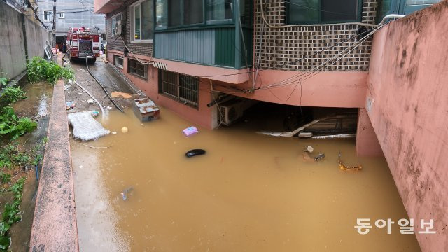 지난 밤 집중호우로 서울 관악구 반지하 주택이 폭우로 침수되면서 일가족 3명이 갇혀있다는 신고가 접수 됐지만 결국 일가족 전원이 사망했다. 9일 오후까지 소방관들이 지하에 가득찬 물을 빼내고 있다.  홍진환 기자 jean@donga.com