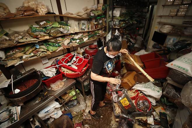 5년째 서울 동작구 남성시장에서 한과와 농산물 등을 판매하는 강아무개씨(56)가 9일 오전 전날 내린 폭우로 쑥대밭이 된 가게 내부를 정리하고 있다. 전날 저녁 8시께 빗물이 갑자기 가게 안으로 밀려들어와 탁자 위로 급히 몸을 피했다는 강씨는 5년동안 이렇게 수해 피해가 컸던 적은 처음이라고 말했다. 김혜윤 기자 unique@hani.co.kr