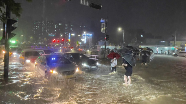 중부지방을 중심으로 폭우가 쏟아진 전날(8일) 밤 서울 관악구 도림천이 범람, 시민들이 아슬아슬하게 물살을 헤쳐 길을 건너고 있다./사진=뉴스1