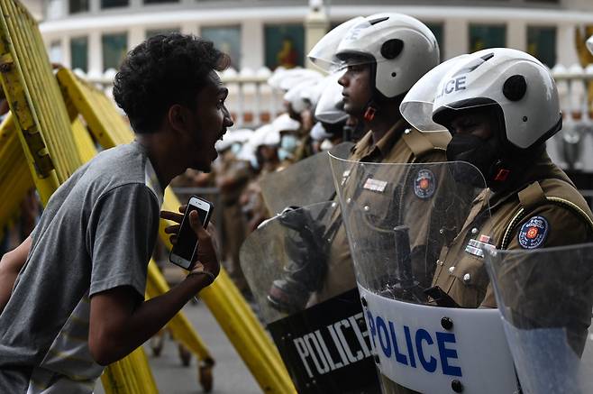 지난달 22일 스리랑카의 수도 콜롬보에서 라닐 위크레메싱게 신임 대통령에 반대하는 시위에 나선 한 시민이 도로를 통제하고 있는 경찰에게 고성을 지르며 항의하고 있다.