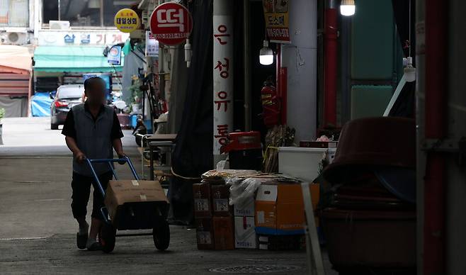 서울 시내의 한 건어물시장에서 상인이 수레를 끌고 있다. 연합뉴스