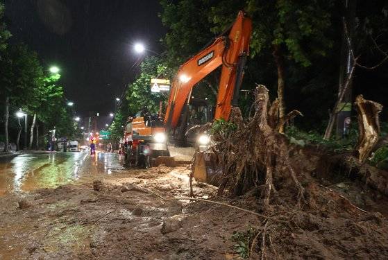 폭우가 내린 9일 오전 서울 서초구의 한 도로에 산사태가 발생해 일부 차선 통제와 복구 작업이 이뤄지고 있다. 연합뉴스