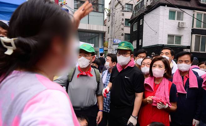 11일 폭우 피해를 입은 서울 동작구 사당2동 주민센터 앞에서 한 시민이 수해복구 자원봉사를 위해 찾은 주호영 국민의힘 비상대책위원장과 권성동 원내대표 등 일행이 길을 막고 있다며 항의하고 있다. /뉴스1