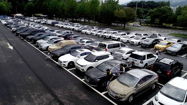 11일 오후 경기도 과천 서울대공원 주차장에 마련된 DB손해보험, 현대해상 임시 보상서비스센터에 연일 내린 집중호우에 침수 피해를 입은 차량들이 주차되어 있다. 연합뉴스