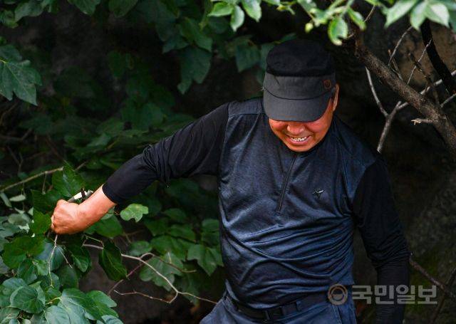 11일 강원도 춘천 소양강댐이 개방한 가운데 이를 구경하기 위해 방문한 시민이 나뭇가지를 꺾은 뒤 웃고 있다.