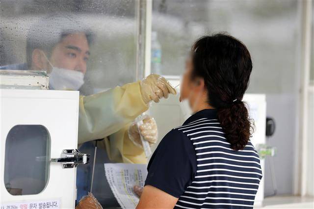 ‘아~~’ - 11일 오후 광주 서구 치평동 5?18교육관 주차장에 마련된 임시 선별진료소에서 시민들이 검사를 받고 있다.광주시는 코로나19가 재확산하자 71일 만에 선별진료소 운영을 재개했다. 2022.8.11 뉴스1
