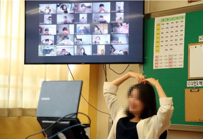 코로나19 유행이 한창이던 2020년 5월 14일 경기 성남시 운중중학교에서 학생들이 화상 수업을 시작하기 전 교사와 인사를 나누고 있다. [동아DB]