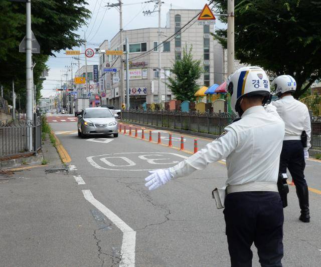 경찰관들이 지난달 12일 충북 청주시 상당구 용암동의 한 초등학교 근처 스쿨존에서 차량 계도 활동을 하고 있다. 청주=뉴시스