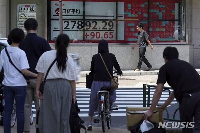 [도쿄=AP/뉴시스] 일본 수도 도쿄 시내 증시 전광판 앞에 있는 횡단보도에서 시민들이 신호를 기다리고 있다. 2022.08.08