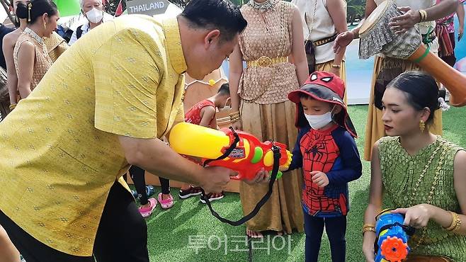 유타삭 태국관광청장이 보령해양머드박람회장 태국부스에서 아이에게 물총 사용법을 설명하고 있다.