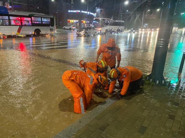지난 10일 충북 청주시 상당구에서 호우로 도로가 침수되자 출동한 소방대원들이 배수 작업을 하고 있다. 소방청 제공