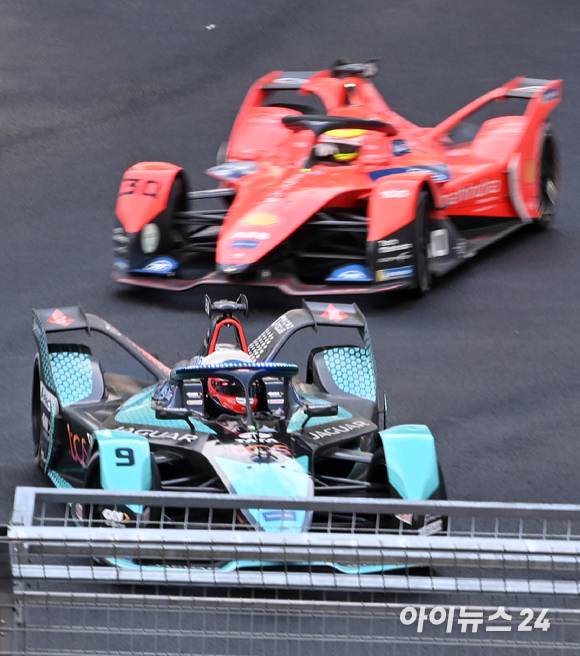 13일 서울 송파구 잠실올림픽주경기장 일대에서 열린 '2022 하나은행 서울 E-프리(E-Prix)' 15라운드 본선에서 재규어 TCS 레이싱 팀 소속 미치 에반스(뉴질랜드)와 마힌드라 레이싱 팀 소속 올리버 롤랜드(영국)가 질주하고 있다. [사진=김성진 기자]