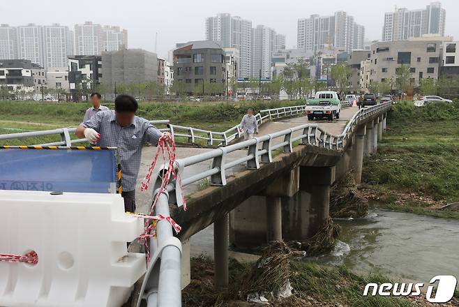 11일 경기도 고양시 창릉천의 한 다리가 집중호우로 교각이 내려 앉아 상판이 붕괴돼 관계자들이 출입통제 작업을 하고 있다. 2022.8.11/뉴스1 ⓒ News1 송원영 기자