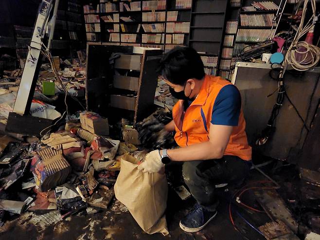 침수 피해를 입은 서울 동작구 상도동의 한 만화카페에서 자원봉사자가 물에 젖은 만화책을 치우고 있다. /김민소 기자