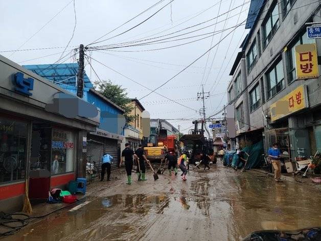 부여군 공무원과 자원봉사자들이 은산면 시가지에서 응급 복구작업을 하고 있다. 뉴스1