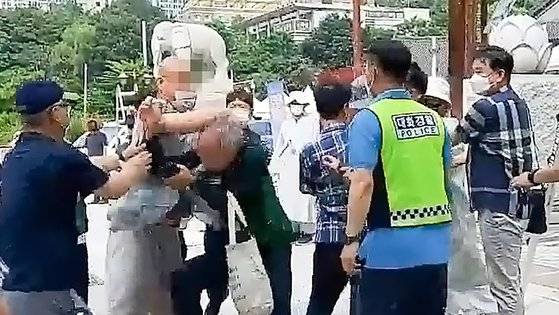 14일 서울 강남구 봉은사 앞에서 자승 전 조계종 총무원장의 종단 선거 개입 등을 비판하는 1인 시위를 준비하던 조계종 노조원에게 한 승려(왼쪽 두번째)가 폭력을 행사하고 있다. 연합뉴스